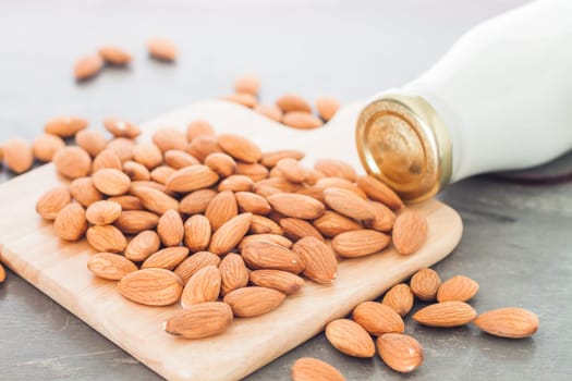 Almond nuts on wooden plate with milk, stock photo