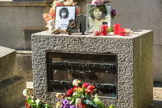 PARIS, FRANCE - SEPT 12, 2014:Jim Morrison grave in Pere-Lachaise cemetery, Paris. Each year thousands fans and curious visitors come to pay homage to Jim Morrison's grave