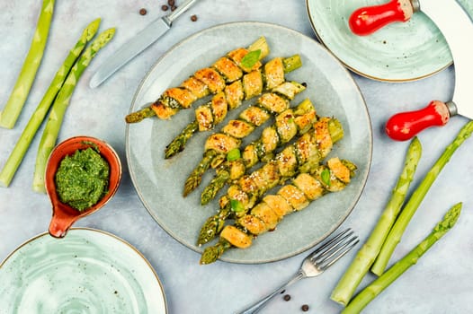 Delicious bread sticks stuffed with asparagus and pesto sauce on a plate. Top view.