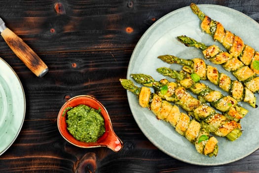 Delicious bread sticks stuffed with asparagus and pesto sauce on a plate. Top view.