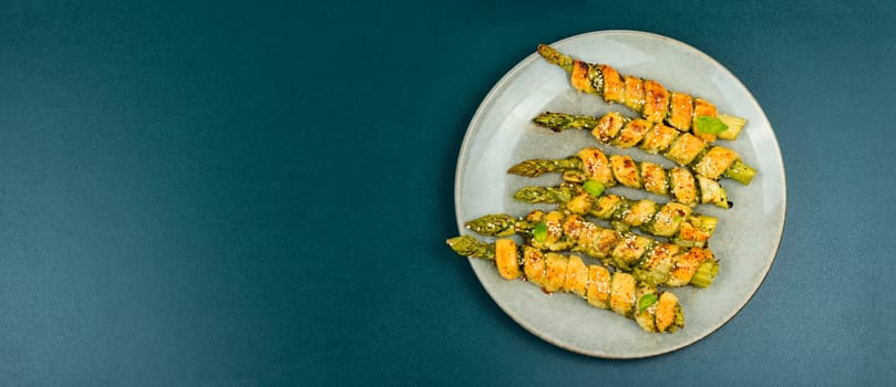 Delicious bread sticks stuffed with asparagus and pesto sauce on a plate. Top view.