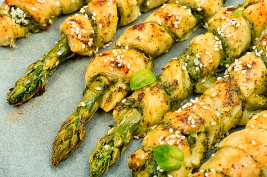 Delicious bread sticks stuffed with asparagus and pesto sauce on a plate. Top view.