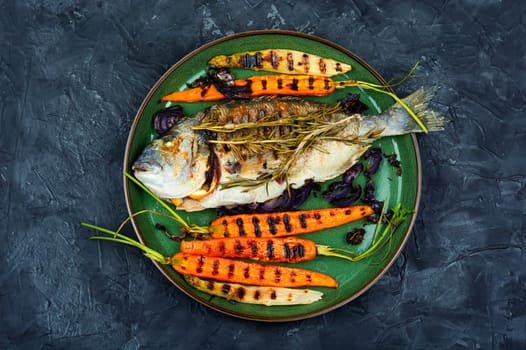 Barbecue whole dorado fish or sea bream with grilled vegetables.