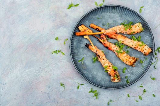 Tasty shrimp barbecue with herbs fried on wooden sticks. Prawns skewers. Space for text