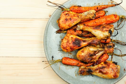 Grilled chicken drumsticks, roast chicken legs with carrots. Copy space