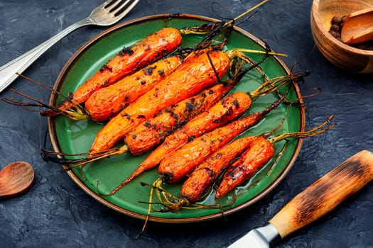 Baked with herbs and spices carrots. Tasty vegetable dish.