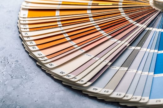Industrial color palette guide of paint samples catalog on grey background, selective focus