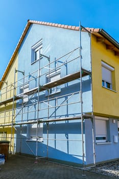 Modern house under construction with scaffold pole platform. New build domestic building