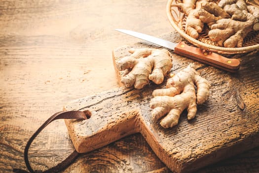 Fresh organic ginger roots on wooden background.