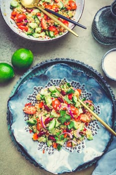 Healthy quinoa black bean salad with fresh tomatoes, cucumbers, onion and cilantro