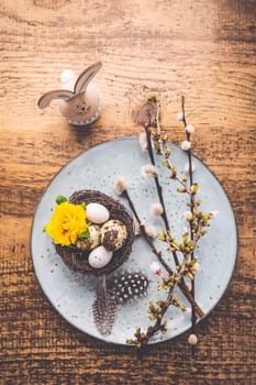 Easter table setting with spring flowers and cutlery on wooden table. Spring Easter Holiday Table