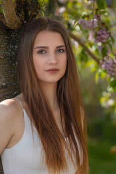 Attractive long hair brunette girl posing on camera outdoors. Vertically.
