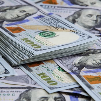 Cash hundred dollar bills, dollar background image. A stack and roll of one hundred American bills