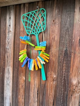 colorful clothespins hang on the wooden fence