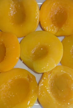Plate of peaches halves in syrup. Overhead shot
