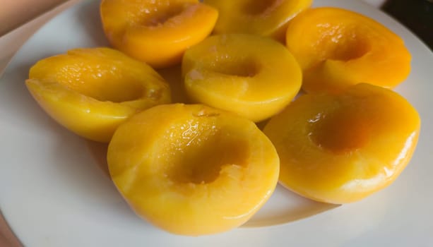 Plate of peaches halves in syrup. Selective focus