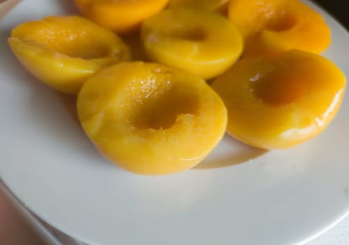 Plate of peaches halves in syrup. Selective focus