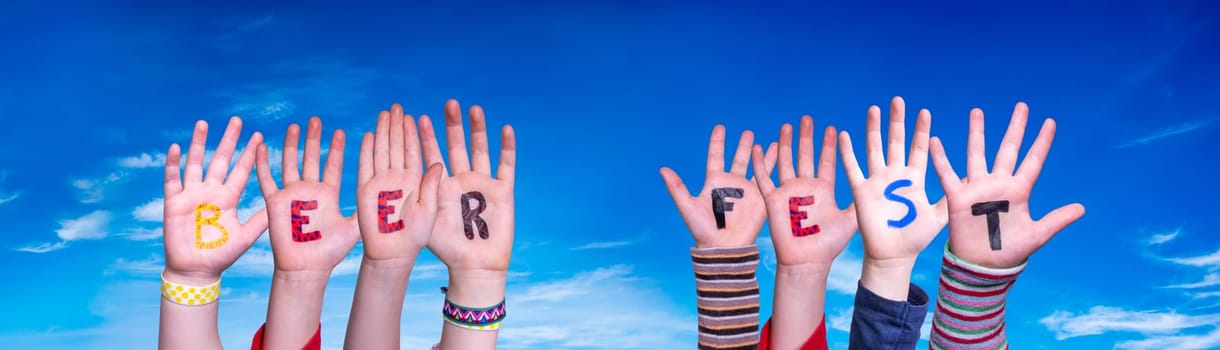 Children Hands Building Colorful English Word Beer Fest. Blue Sky As Background.