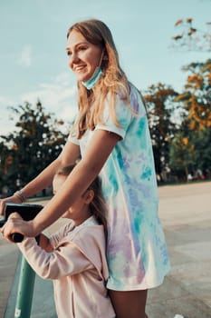 Teenager girl and her sister preschooler riding an electric scooter in the city center. Concept of happy family. Candid people, real moments, authentic situation