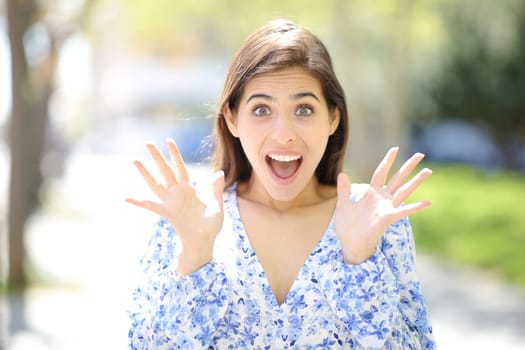 Front view of an amazed woman looking at camera in the street