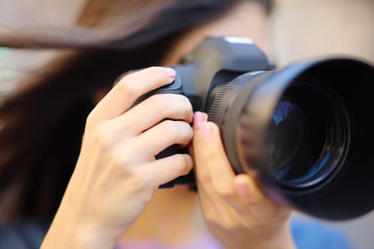 Close up of a photographer taking photos with reflex camera outdoors