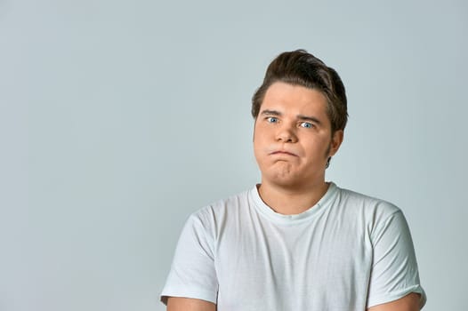 a frowning man on a gray background, copy space. High quality photo