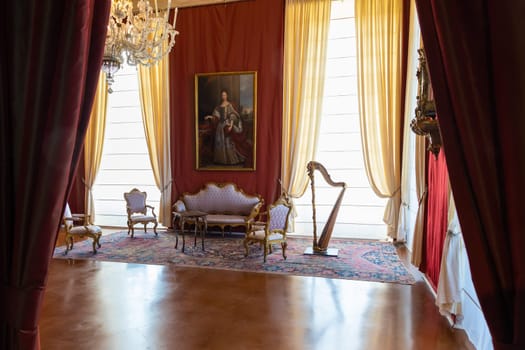 Venaria Reale, Italy - February 2023: luxury interior, old Royal Palace. Perspective with harp, window and baroque decoration.