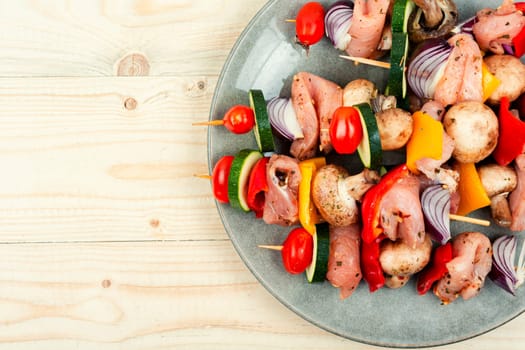 Skewers with pieces of raw meat and vegetables. Barbecue meat spices and herbs.