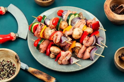 Skewers with pieces of raw meat and vegetables. Barbecue meat spices and herbs.