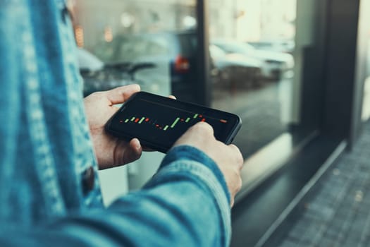 Person investing trading on stock cryptocurrency market using investing application on smartphone. Stock market investment in hand. Trader holding mobile phone looking at candle chart