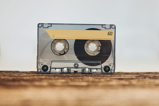 Tape cassette. Magnetic cassette tape on wooden table. Retro music style. 80s music party. Vintage style. Analog equipment. Stereo sound. Back to the past