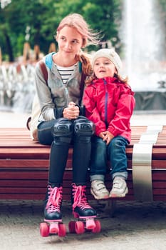 Sisters sitting on bench in a town