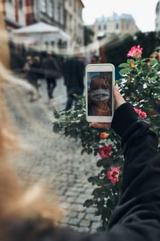 Young woman having video call talking while walking downtown in the evening wearing the face mask to avoid virus infection and to prevent the spread of disease in time of coronavirus