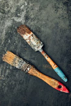 Paintbrushes on metal surface. Old brush set for house maintenance. Technical background with copy space