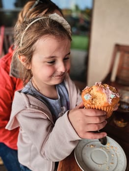 Girl enjoying eating sweet tasty cupcake that you she made herself at home