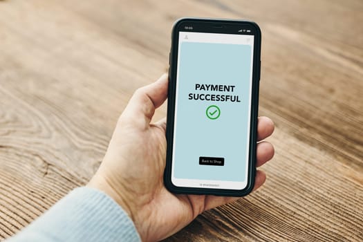 Man paying with smartphone for online shopping. Paying using fast secure payment system. Paying bills using express payment technology. Paying expenses online. Ordering product online using smartphone. Confirmation payment successful displayed in store app on smartphone screen. Express payment