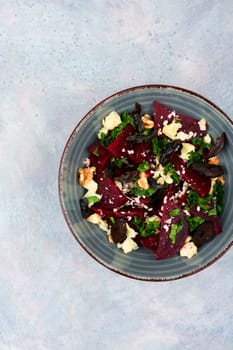 Diet salad of beets, nuts and cheese on the plate.
