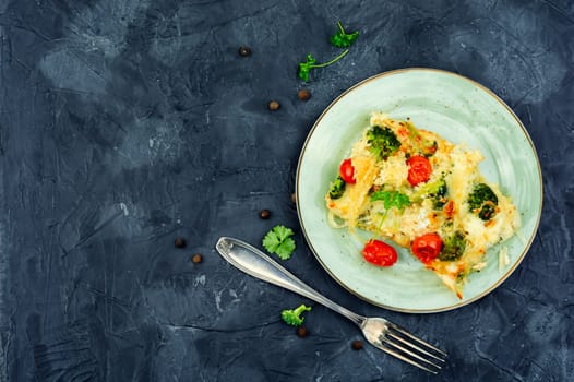 Diet potato casserole with broccoli and tomatoes on a plate. copy space,space for text