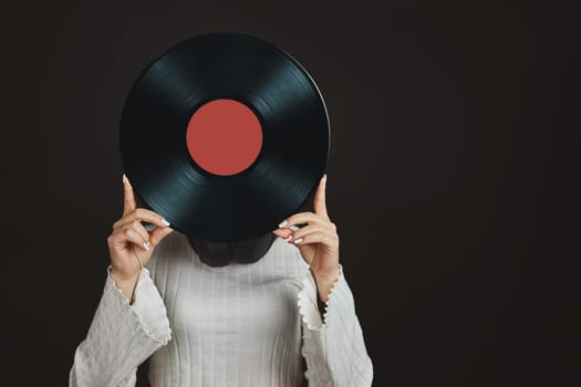 Woman holding vinyl record. Music passion. Listening to music from analog record. Playing music from analog disk on turntable player. Enjoying music from old collection. Retro and vintage. Stereo audio. Analog sound