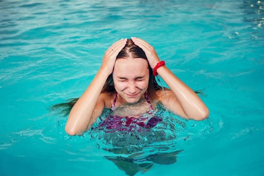 Young woman swimming and relaxing in swimming pool. Candid people, real moments, authentic situations