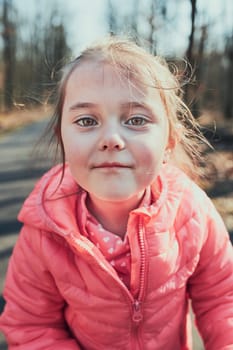 Portrait of little girl playing in the park, having fun on sunny autumn day. Real people, authentic situations