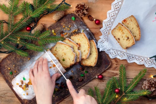 Famale hand cutting the Christmas cake to pieces