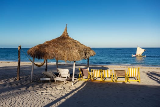 Tranquil and beautiful day on Anakao beach in Madagascar, with a clear blue sky, a comfortable sun lounger, and a colorful parasol for your ultimate relaxation. Toliara, Madagascar