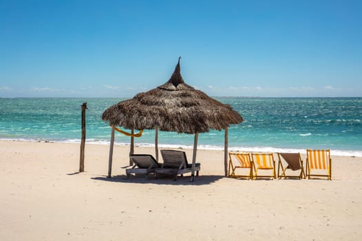 Tranquil and beautiful day on Anakao beach in Madagascar, with a clear blue sky, a comfortable sun lounger, and a colorful parasol for your ultimate relaxation. Toliara, Madagascar