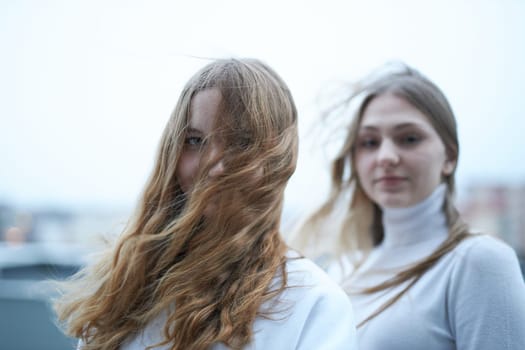 Two young woman looking at camera outdoors. Portrait of teenage girls