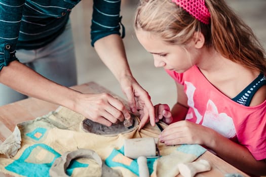 Girl making her first pottery in ceramic workshop