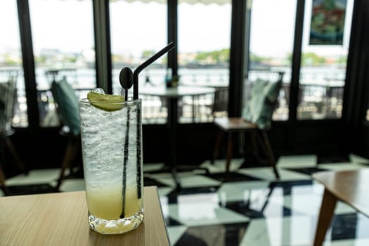 Lemonade looks delicious, cool and refreshing in a classic style cafe by the river. The atmosphere is pleasant to sit and listen to chill music for a long time. It is a horizontal picture.