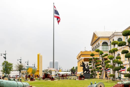 Bangkok,Thailand- April16, 2023: Building of the Ministry of Defense of Thailand​ It is a European-style building, yellow, with a white line. In front of the building there are 40 antique real cannons