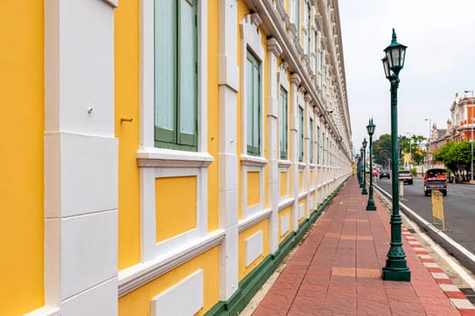 Bangkok,Thailand - April 16, 2023: The yellow building contrasts with the white stripes and has light green windows of Thailand's Ministry of Defense. A popular spot for tourists to take pictures.