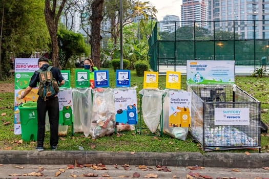 Bangkok, Thailand - Dec 8, 2022: A man throws rubbish by categories organized by government agencies at the Red Cross Fair at Lumpini Park from Dec 8-18, 2022. The image is blurred because of movement